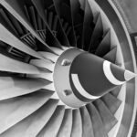 Detailed black and white photograph of aircraft turbine engine blades showcasing engineering precision.